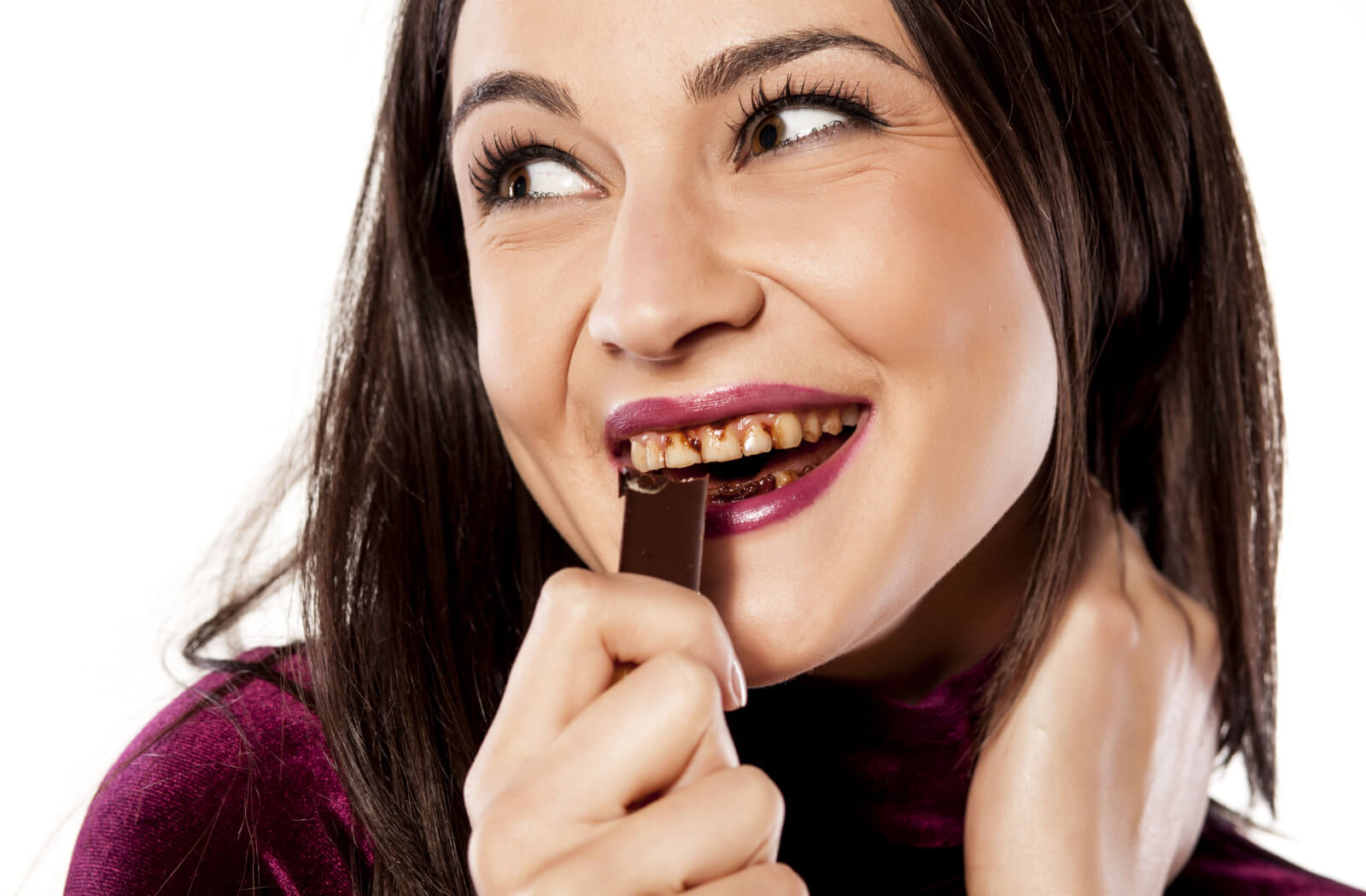 A woman with stained teeth from eating a bar of chocolate.
